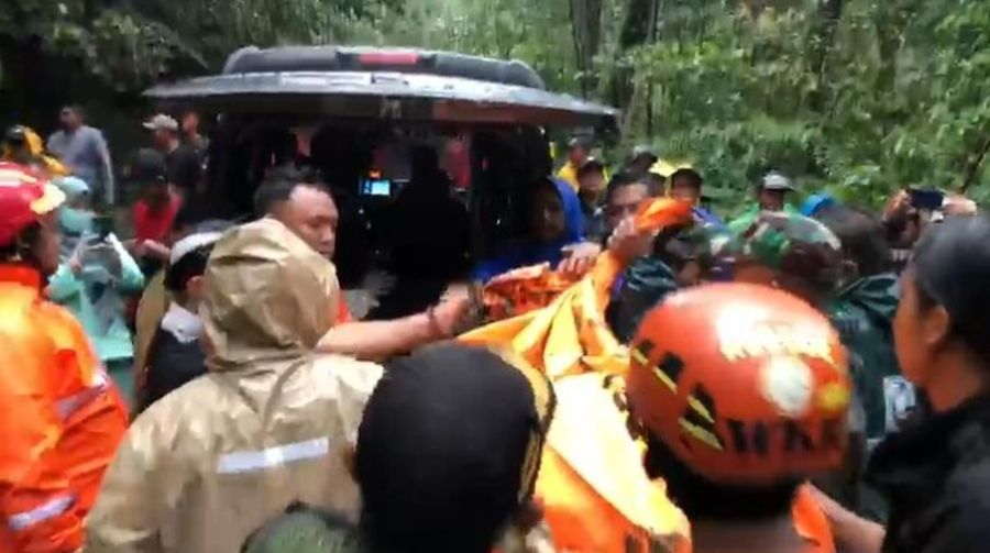 Rescuers search for victims after a rain-triggered landslide hit passing cars on a road in Mojokerto, East Java, Indonesia, Friday, April 4, 2025. (AP Photo)