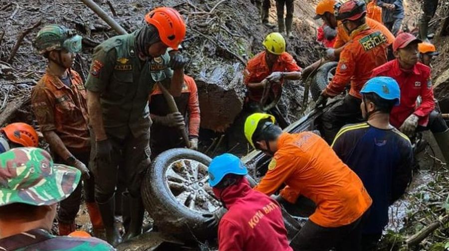 Rescuers search for victims after a rain-triggered landslide hit passing cars on a road in Mojokerto, East Java, Indonesia, Friday, April 4, 2025. (AP Photo)