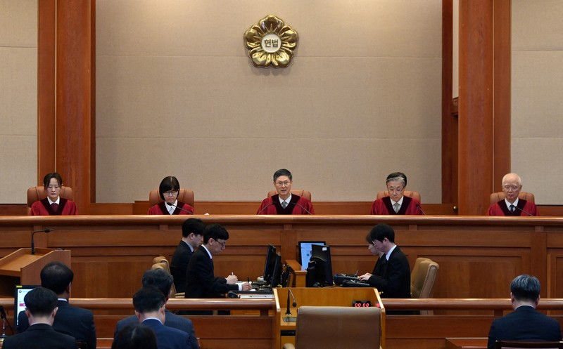 Orang-orang menonton laporan berita langsung sambil menunggu putusan Mahkamah Konstitusi atas pemakzulan Presiden Yoon Suk Yeol, di dekat Mahkamah Konstitusi di Seoul, Korea Selatan, 4 April 2025. (REUTERS/Kim Hong-Ji) Orang-orang menonton laporan berita langsung sambil menunggu putusan Mahkamah Konstitusi atas pemakzulan Presiden Yoon Suk Yeol, di dekat Mahkamah Konstitusi di Seoul, Korea Selatan, 4 April 2025. (REUTERS/Kim Hong-Ji)