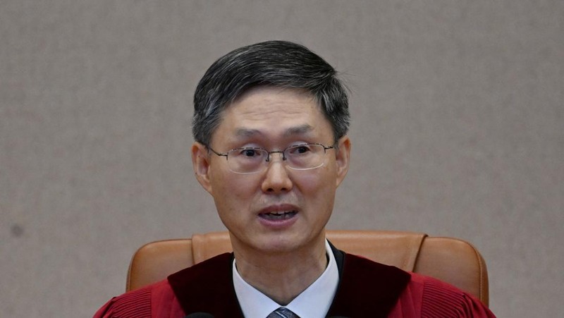 Orang-orang menonton laporan berita langsung sambil menunggu putusan Mahkamah Konstitusi atas pemakzulan Presiden Yoon Suk Yeol, di dekat Mahkamah Konstitusi di Seoul, Korea Selatan, 4 April 2025. (REUTERS/Kim Hong-Ji)