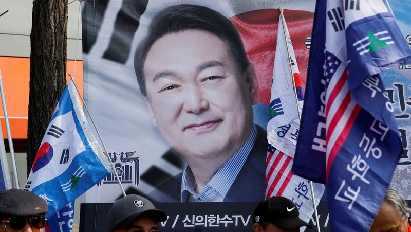 Orang-orang menonton laporan berita langsung sambil menunggu putusan Mahkamah Konstitusi atas pemakzulan Presiden Yoon Suk Yeol, di dekat Mahkamah Konstitusi di Seoul, Korea Selatan, 4 April 2025. (REUTERS/Kim Hong-Ji)
