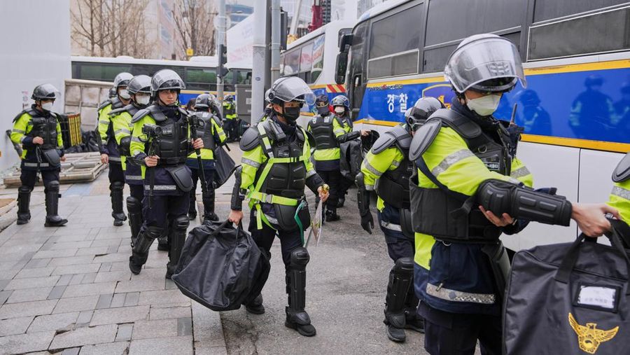 Petugas polisi berjaga saat para pengunjuk rasa bersiap berbaris menuju Mahkamah Konstitusi selama unjuk rasa menuntut agar Presiden Korea Selatan yang dimakzulkan Yoon Suk Yeol mengundurkan diri di dekat Gwanghwamun, gerbang utama Istana Gyeongbok abad ke-14, di Seoul, Korea Selatan, Kamis, (4/4/2025). (AP Photo/Ahn Young-joon)