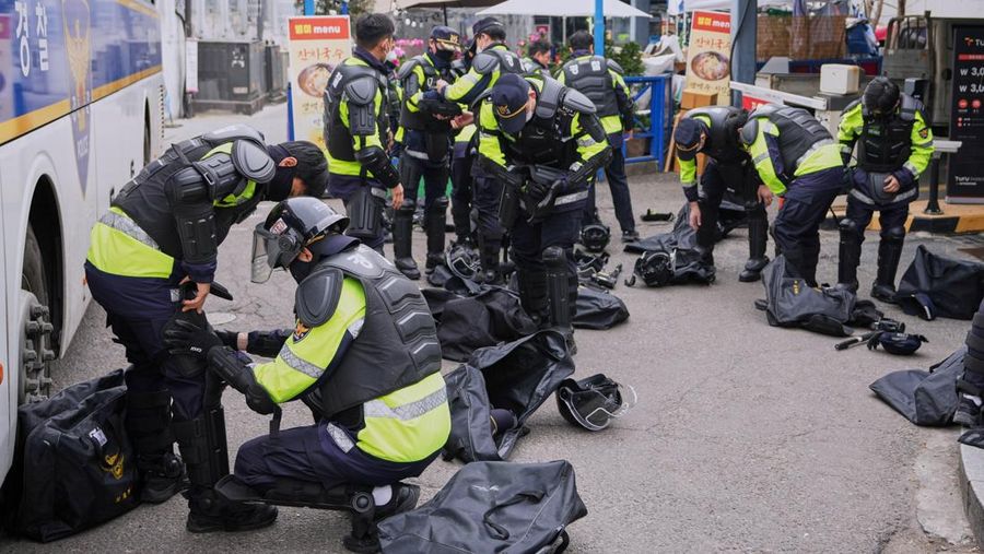 Petugas polisi berjaga saat para pengunjuk rasa bersiap berbaris menuju Mahkamah Konstitusi selama unjuk rasa menuntut agar Presiden Korea Selatan yang dimakzulkan Yoon Suk Yeol mengundurkan diri di dekat Gwanghwamun, gerbang utama Istana Gyeongbok abad ke-14, di Seoul, Korea Selatan, Kamis, (4/4/2025). (AP Photo/Ahn Young-joon)