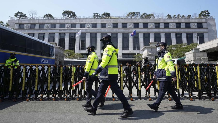 Petugas polisi berjaga saat para pengunjuk rasa bersiap berbaris menuju Mahkamah Konstitusi selama unjuk rasa menuntut agar Presiden Korea Selatan yang dimakzulkan Yoon Suk Yeol mengundurkan diri di dekat Gwanghwamun, gerbang utama Istana Gyeongbok abad ke-14, di Seoul, Korea Selatan, Kamis, (4/4/2025). (AP Photo/Ahn Young-joon)