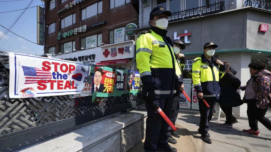 Petugas polisi berjaga saat para pengunjuk rasa bersiap berbaris menuju Mahkamah Konstitusi selama unjuk rasa menuntut agar Presiden Korea Selatan yang dimakzulkan Yoon Suk Yeol mengundurkan diri di dekat Gwanghwamun, gerbang utama Istana Gyeongbok abad ke-14, di Seoul, Korea Selatan, Kamis, (4/4/2025). (AP Photo/Ahn Young-joon)