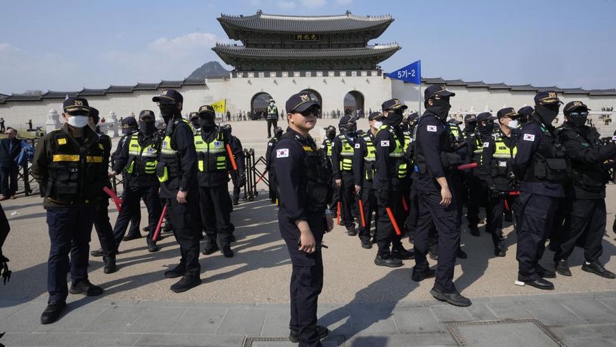 Petugas polisi berjaga saat para pengunjuk rasa bersiap berbaris menuju Mahkamah Konstitusi selama unjuk rasa menuntut agar Presiden Korea Selatan yang dimakzulkan Yoon Suk Yeol mengundurkan diri di dekat Gwanghwamun, gerbang utama Istana Gyeongbok abad ke-14, di Seoul, Korea Selatan, Kamis, (4/4/2025). (AP Photo/Ahn Young-joon)