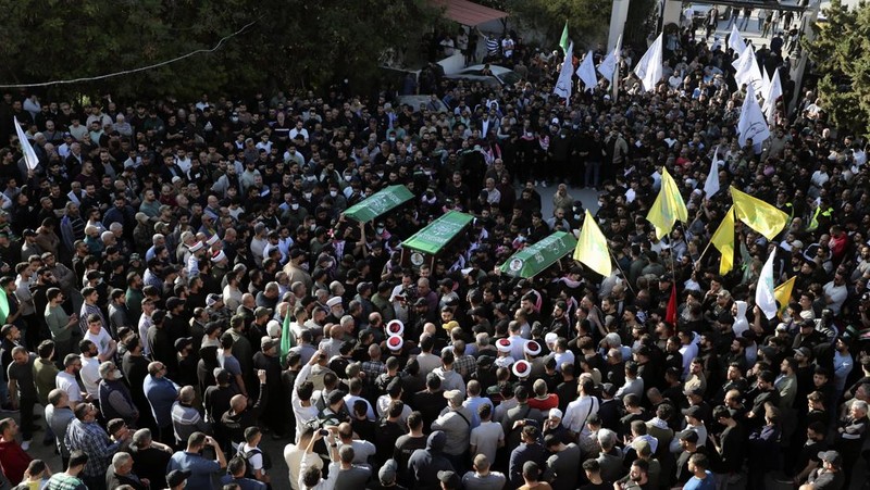 Para pelayat membawa peti jenazah Hassan Farhat, komandan Sektor Barat Hamas saat prosesi pemakaman di Lebanon, Jumat (4/4/2025) waktu setempat. (AP Photo/Mohammed Zaatari)