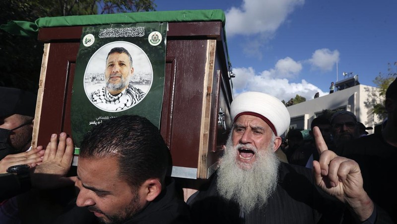 Para pelayat membawa peti jenazah Hassan Farhat, komandan Sektor Barat Hamas saat prosesi pemakaman di Lebanon, Jumat (4/4/2025) waktu setempat. (AP Photo/Mohammed Zaatari)