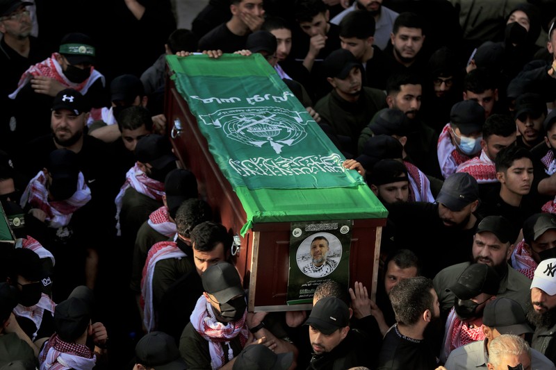 Para pelayat membawa peti jenazah Hassan Farhat, komandan Sektor Barat Hamas saat prosesi pemakaman di Lebanon, Jumat (4/4/2025) waktu setempat. (AP Photo/Mohammed Zaatari)