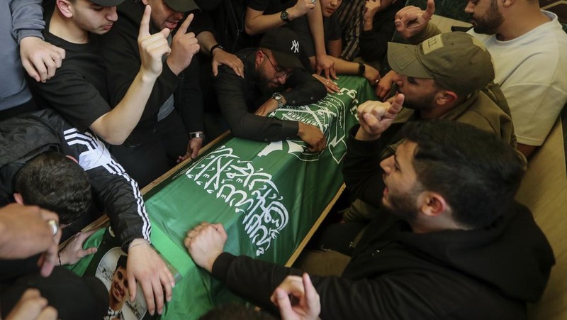 Para pelayat membawa peti jenazah Hassan Farhat, komandan Sektor Barat Hamas saat prosesi pemakaman di Lebanon, Jumat (4/4/2025) waktu setempat. (AP Photo/Mohammed Zaatari)