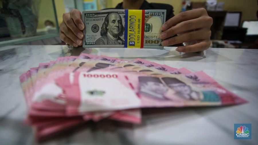 Petugas menjunjukkan uang pecahan dolar AS dan rupiah di Dolarindo Money Changer, Jakarta, Selasa (8/4/2025). (²©²ÊÍøÕ¾/Faisal Rahman)
