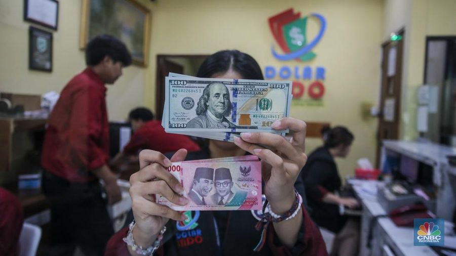 Petugas menjunjukkan uang pecahan dolar AS dan rupiah di Dolarindo Money Changer, Jakarta, Selasa (8/4/2025). (²©²ÊÍøÕ¾/Faisal Rahman)