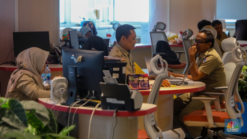 Sejumlah Aparatur Sipil Negara (ASN) menyelesaikan pekerjaannya di Gedung Balai Kota DKI Jakarta, Selasa (8/4/2025). (CNBC Indonesia/Faisal Rahman)