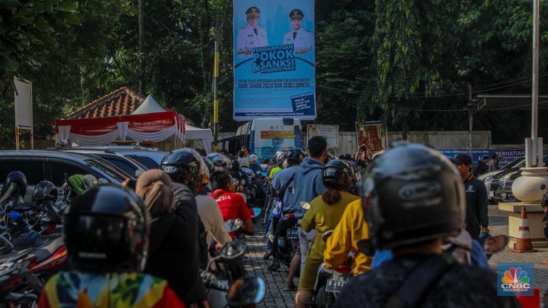 Warga antre untuk melakukan pemeriksaan fisik kendaraan wajib pajak untuk pengurusan pembayaran pajak kendaraan bermotor di kantor Samsat Ciputat, Tangerang Selatan, Banten, Jumat (11/4/2025). (CNBC Indonesia/Faisal Rahman)