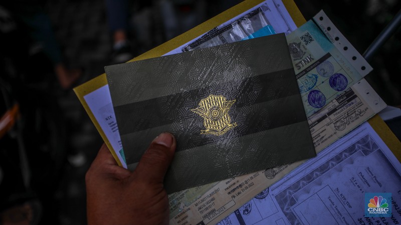 Warga antre untuk melakukan pemeriksaan fisik kendaraan wajib pajak untuk pengurusan pembayaran pajak kendaraan bermotor di kantor Samsat Ciputat, Tangerang Selatan, Banten, Jumat (11/4/2025). (CNBC Indonesia/Faisal Rahman)