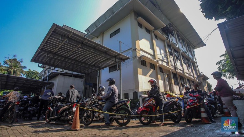 Warga antre untuk melakukan pemeriksaan fisik kendaraan wajib pajak untuk pengurusan pembayaran pajak kendaraan bermotor di kantor Samsat Ciputat, Tangerang Selatan, Banten, Jumat (11/4/2025). (CNBC Indonesia/Faisal Rahman)
