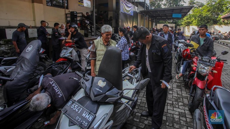 Warga antre untuk melakukan pemeriksaan fisik kendaraan wajib pajak untuk pengurusan pembayaran pajak kendaraan bermotor di kantor Samsat Ciputat, Tangerang Selatan, Banten, Jumat (11/4/2025). (CNBC Indonesia/Faisal Rahman)