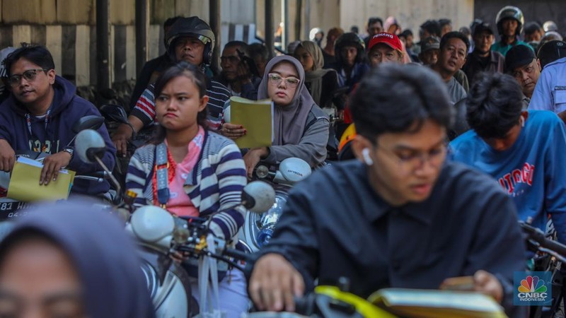 Warga antre untuk melakukan pemeriksaan fisik kendaraan wajib pajak untuk pengurusan pembayaran pajak kendaraan bermotor di kantor Samsat Ciputat, Tangerang Selatan, Banten, Jumat (11/4/2025). (CNBC Indonesia/Faisal Rahman)