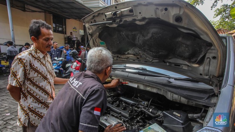 Warga antre untuk melakukan pemeriksaan fisik kendaraan wajib pajak untuk pengurusan pembayaran pajak kendaraan bermotor di kantor Samsat Ciputat, Tangerang Selatan, Banten, Jumat (11/4/2025). (CNBC Indonesia/Faisal Rahman)
