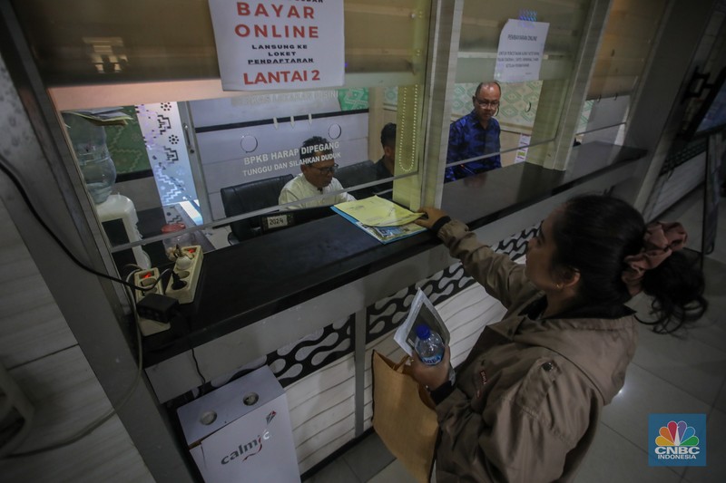 Warga antre untuk melakukan pemeriksaan fisik kendaraan wajib pajak untuk pengurusan pembayaran pajak kendaraan bermotor di kantor Samsat Ciputat, Tangerang Selatan, Banten, Jumat (11/4/2025). (CNBC Indonesia/Faisal Rahman)