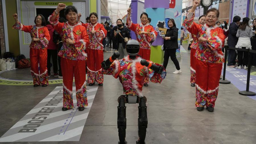 A robot leads elderly Chinese women to perform a cultural dance at an AI Exhibition in Beijing, Wednesday, April 9, 2025. (AP Photo/Ng Han Guan)