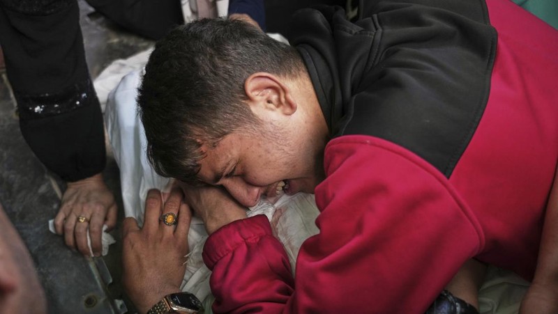 Palestinians inspect the damage caused by an Israeli army targeted strike that killed at least three people in Deir al-Balah, central Gaza Strip, Sunday, April 13, 2025. (AP Photo/Abdel Kareem Hana)