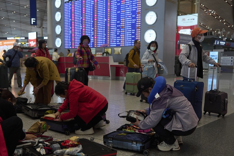 China Wild Winds A traveller walks past by a board showing flights that are cancelled at the Capital International Airport Terminal 3 following gale wind alerts in Beijing, China, Saturday, April 12, 2025. (AP Photo/Ng Han Guan)