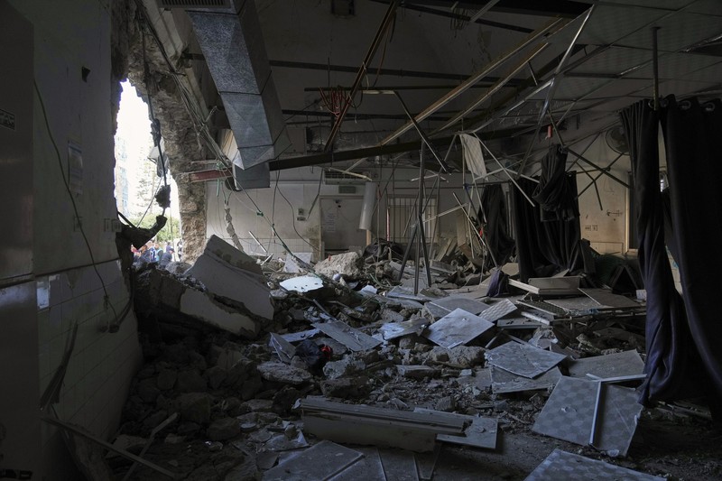 Palestinians inspect the damage caused by an Israeli army targeted strike that killed at least three people in Deir al-Balah, central Gaza Strip, Sunday, April 13, 2025. (AP Photo/Abdel Kareem Hana)