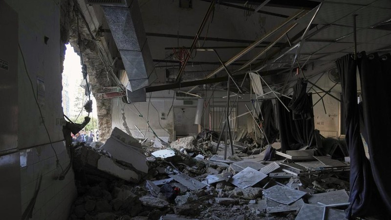 Palestinians inspect the damage caused by an Israeli army targeted strike that killed at least three people in Deir al-Balah, central Gaza Strip, Sunday, April 13, 2025. (AP Photo/Abdel Kareem Hana)