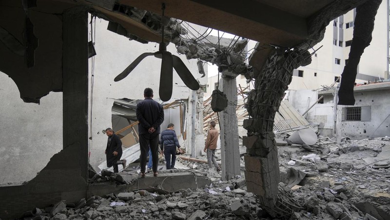 Palestinians inspect the damage caused by an Israeli army targeted strike that killed at least three people in Deir al-Balah, central Gaza Strip, Sunday, April 13, 2025. (AP Photo/Abdel Kareem Hana)
