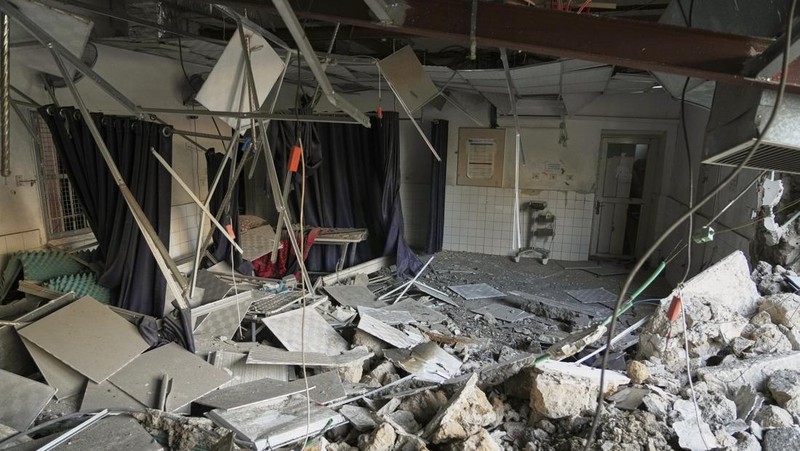 Palestinians inspect the damage caused by an Israeli army targeted strike that killed at least three people in Deir al-Balah, central Gaza Strip, Sunday, April 13, 2025. (AP Photo/Abdel Kareem Hana)