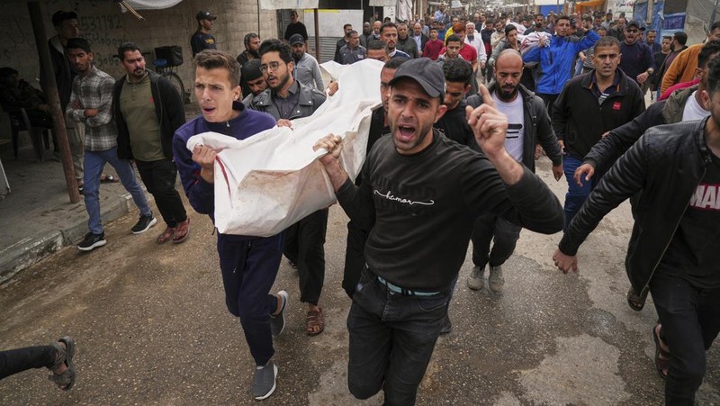 Palestinians inspect the damage caused by an Israeli army targeted strike that killed at least three people in Deir al-Balah, central Gaza Strip, Sunday, April 13, 2025. (AP Photo/Abdel Kareem Hana)