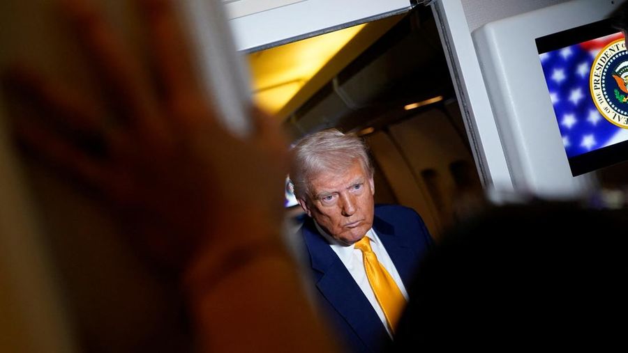 U.S. President Donald Trump listens to the media on board Air Force One on the way to Miami, Florida, U.S., April 12, 2025. REUTERS/Nathan Howard