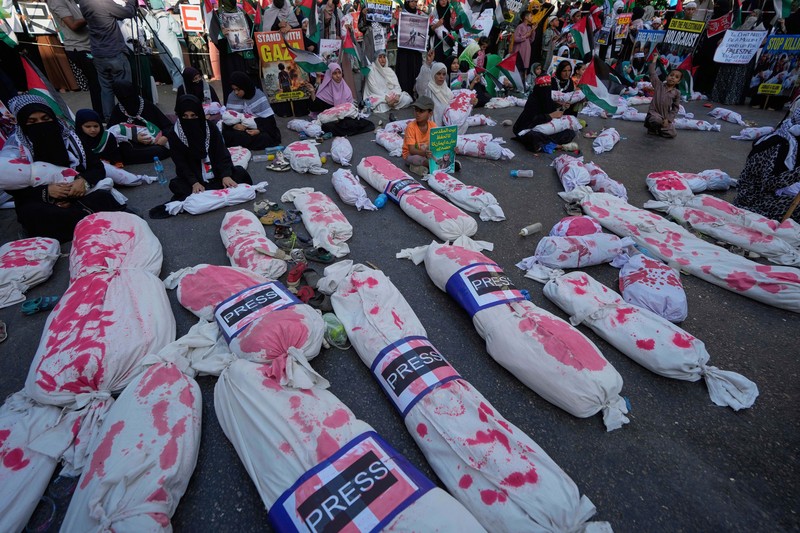 Orang-orang mengibarkan bendera selama unjuk rasa pro-Palestina yang disebut 