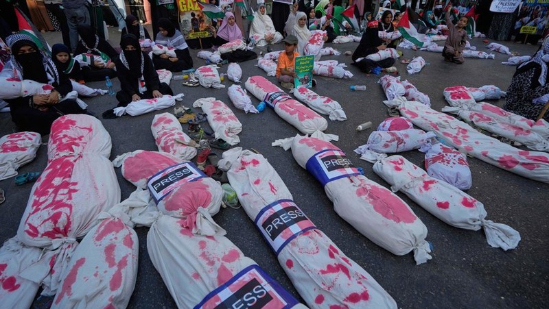 Orang-orang mengibarkan bendera selama unjuk rasa pro-Palestina yang disebut 