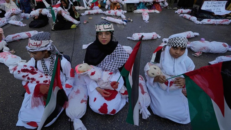 Orang-orang mengibarkan bendera selama unjuk rasa pro-Palestina yang disebut 