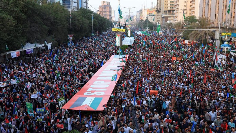 Orang-orang mengibarkan bendera selama unjuk rasa pro-Palestina yang disebut 