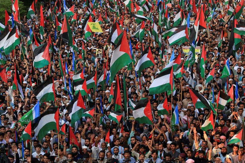 Orang-orang mengibarkan bendera selama unjuk rasa pro-Palestina yang disebut Orang-orang mengibarkan bendera selama unjuk rasa pro-Palestina yang disebut