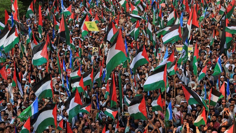 Orang-orang mengibarkan bendera selama unjuk rasa pro-Palestina yang disebut 