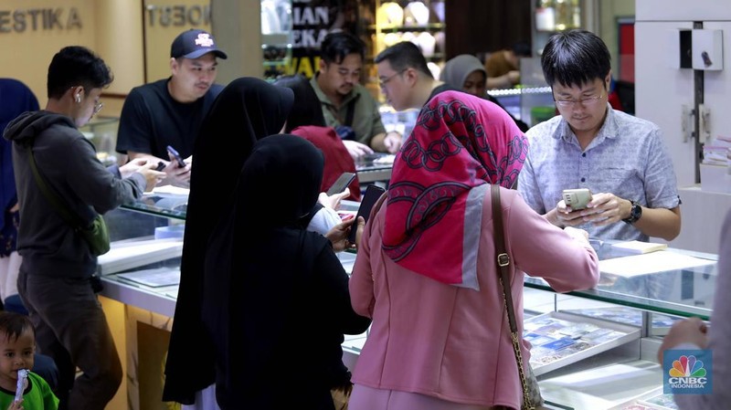 Pengunjung membeli emas perhiasan dan logam mulia di Butik Galeri 24, Jakarta, Selasa (15/4/2025). (CNBC Indonesia/Muhammad Sabki)