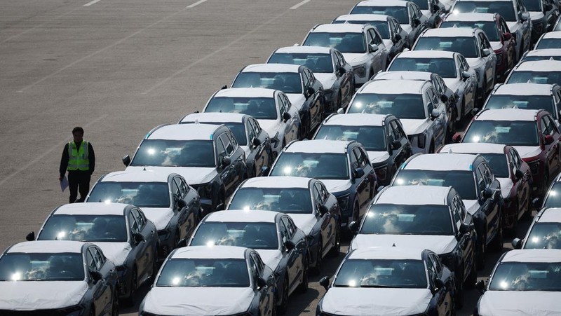Sebuah pengangkut mobil yang mengangkut kendaraan buatan Kia Motors, yang merupakan bagian dari perusahaan pembuat mobil terbesar Korea Selatan, Hyundai Motor, melintasi pohon sakura yang sedang berbunga di dekat pelabuhan Pyeongtaek di Pyeongtaek, Korea Selatan, Selasa (15/4/2024). (REUTERS/Kim Hong-Ji)