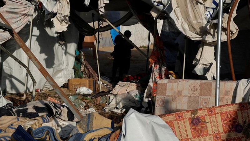 Warga Palestina memeriksa kerusakan di lokasi serangan Israel terhadap tenda yang menampung orang-orang terlantar, di Khan Younis di Jalur Gaza selatan, 15 April 2025. (REUTERS/Hatem Khaled)