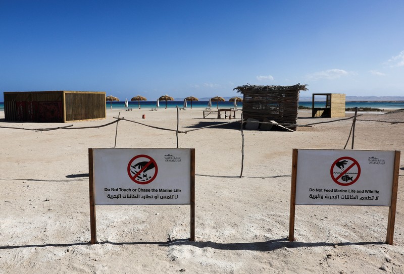 Pemandangan tanda yang dikelilingi penghalang yang terbuat dari tongkat kayu di depan pantai Ras Hankorab di Taman Nasional Wadi el-Gemal, rumah bagi salah satu ekosistem laut terakhir yang masih alami di negara ini dengan air sebening kristal dan pasir putih, di pantai Laut Merah Mesir selatan di Marsa Alam, Mesir 23 Maret 2025. (REUTERS/Stringer)