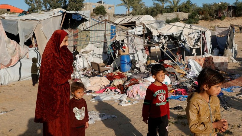Warga Palestina memeriksa kerusakan di lokasi serangan Israel terhadap tenda yang menampung orang-orang terlantar, di Khan Younis di Jalur Gaza selatan, 15 April 2025. (REUTERS/Hatem Khaled)