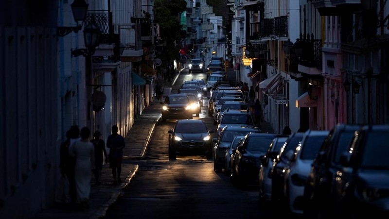 Orang-orang berjalan melalui jalan yang gelap setelah Puerto Riko dilanda pemadaman listrik besar-besaran di mana pembangkit listrik di seluruh pulau tiba-tiba mati, di San Juan, Puerto Riko, 16 April 2025. (REUTERS/Ricardo Arduengo)