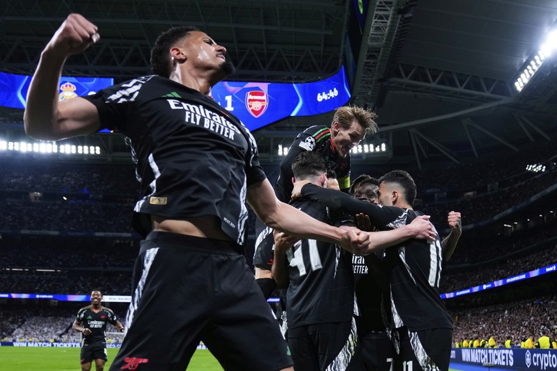 Pemain Arsenal merayakan kemenangan atas Real Madrid 2-1 dalam pertandingan leg kedua perempat final Liga Champions di stadion Santiago Bernabeu di Madrid, Rabu, 16 April 2025. (AP Photo/Manu Fernandez)