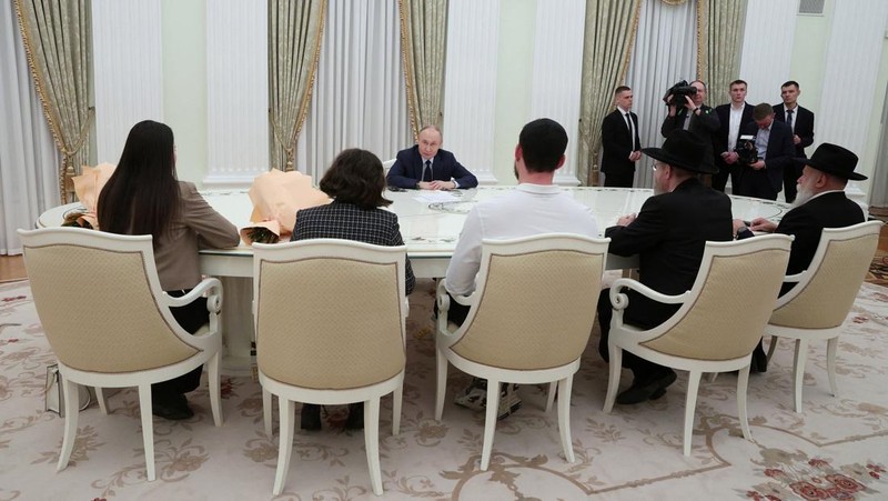 Presiden Rusia Vladimir Putin menemui satu warga Rusia-Israel eks sandera di Jalur Gaza yang baru dilepas Hamas dan diterbangkan ke Moskow, Alexander Trufanov, dan keluarga. (Sandurskaya/Pool via REUTERS)