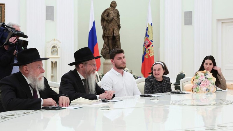 Presiden Rusia Vladimir Putin menemui satu warga Rusia-Israel eks sandera di Jalur Gaza yang baru dilepas Hamas dan diterbangkan ke Moskow, Alexander Trufanov, dan keluarga. (Sandurskaya/Pool via REUTERS)