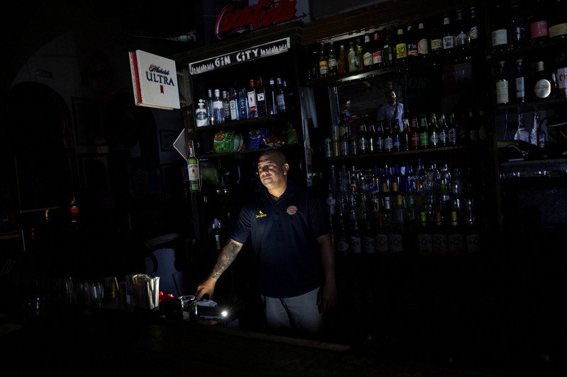 Orang-orang berjalan melalui jalan yang gelap setelah Puerto Riko dilanda pemadaman listrik besar-besaran di mana pembangkit listrik di seluruh pulau tiba-tiba mati, di San Juan, Puerto Riko, 16 April 2025. (REUTERS/Ricardo Arduengo)
