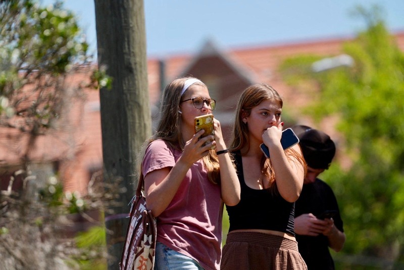 Orang-orang berkumpul saat dievakuasi oleh petugas polisi menyusul tanggapan terhadap laporan penembakan di Universitas Negeri Florida, di Tallahassee, Florida, AS, 17 April 2025, dalam tangkapan layar yang diperoleh dari video media sosial. (@ignqiny via X/via REUTERS)